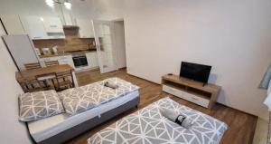a small living room with two beds and a television at Apartament Panorama Centrum in Przemyśl