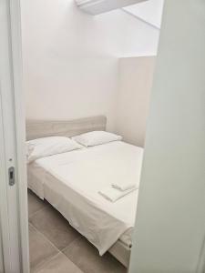 a bedroom with a bed with white sheets and pillows at La Guglia - Maison à Porter in Vasto
