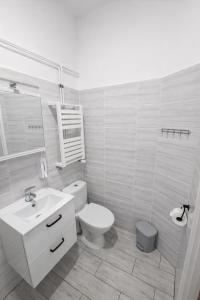 a white bathroom with a toilet and a sink at Apartament Panorama Centrum in Przemyśl +6 photos