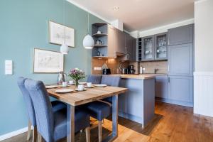 a kitchen and dining room with a wooden table and chairs at Golfresidenz B 002 in Grömitz