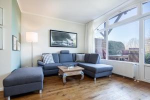 a living room with a blue couch and a table at Golfresidenz B 002 in Grömitz