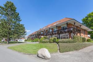 a large building with a rock in front of it at Golfresidenz B 002 in Grömitz
