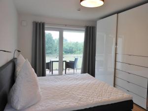 a bedroom with a bed and a view of a patio at Golfresidenz D 1 03 in Grömitz +32 photos