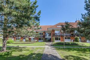 an exterior view of a building with trees at Golfresidenz Landidyll B 107 in Grömitz