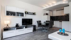 a kitchen and living room with a table and a television at Golfresidenz B 105 in Grömitz