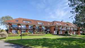 a large building with a lawn and trees at Golfresidenz B 105 in Grömitz