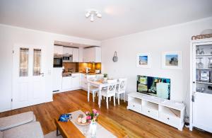 a kitchen and living room with a table and a tv at Golfresidenz B 010 Heimathafen in Grömitz