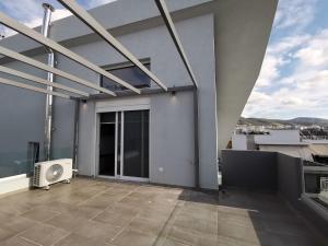 a balcony of a house with a fan at Athenean Rooftop Nest in Athens