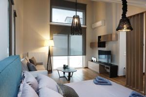 a living room with a couch and a tv at Athenean Rooftop Nest in Athens