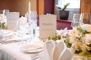 a table with wine glasses and flowers on it at Hotel Restaurant Passmann in Lüdenscheid +2 photos
