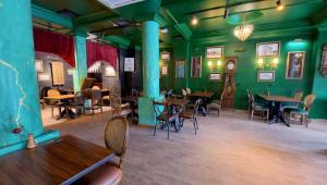 a restaurant with green walls and tables and chairs at THINK HOTEL in Konya