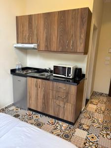 a kitchen with a counter with a microwave and a stove at Mar Mkhayel Studios in Beirut