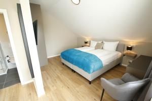 a bedroom with a bed and a chair at Amelie No 3 Hotel & Appartements in Schweigen-Rechtenbach