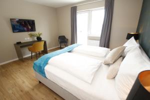 a bedroom with a bed with a desk and a window at Amelie No 3 Hotel & Appartements in Schweigen-Rechtenbach +61 photos