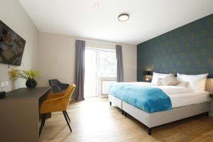 a bedroom with a bed and a desk and a window at Amelie No 3 Hotel & Appartements in Schweigen-Rechtenbach