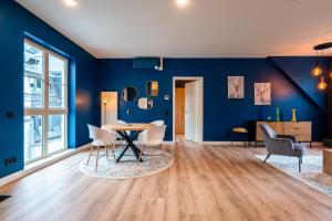 a dining room with blue walls and a table and chairs at Laras Loft in Leipzig +7 photos