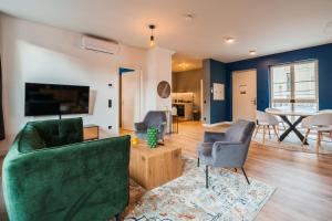 a living room with a green couch and chairs at Laras Loft in Leipzig