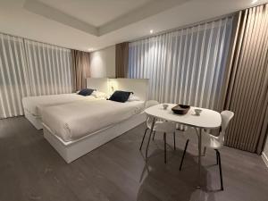 a hotel room with a bed and a table at DADA Stay Hongdae in Seoul