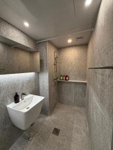 a bathroom with a white sink and a shower at DADA Stay Hongdae in Seoul