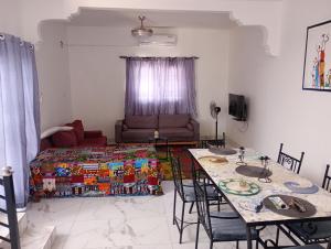 a living room with a table and a bed at Villa Shérazade in Saint-Louis