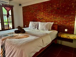 a bed with a teddy bear sitting on top of it at Lombok House Mentigi in Teluknarat