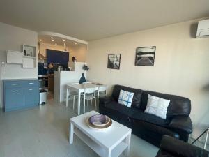 a living room with a couch and a table at Appartement - Bonamour in Capbreton