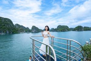 a woman standing on a boat in the water at Thành Trung Motel in Cat Ba