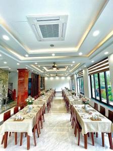 ein großes Esszimmer mit Tischen, Stühlen und Fenstern in der Unterkunft Realux Hotel FLC Sam Son in Sầm Sơn