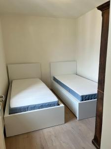 two beds in a room with white walls and wooden floors at Ferienhaus in Piazzogna in Gambarogno