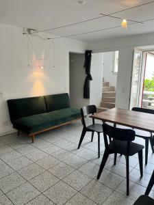a living room with a green couch and a table at Ferienhaus in Piazzogna in Gambarogno