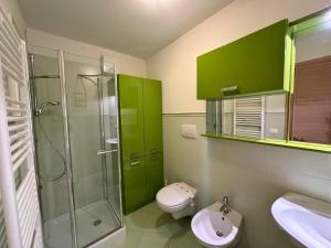 a bathroom with green cabinets and a toilet and a sink at Appartamenti La Croma in Grado +43 photos