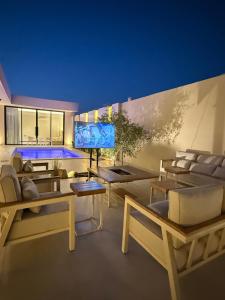 a living room with couches and a flat screen tv at شاليه جازلي in Riyadh
