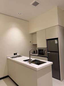 a kitchen with a sink and a refrigerator at شاليه جازلي in Riyadh