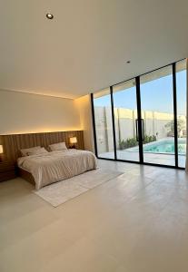 a bedroom with a bed and a large window at شاليه جازلي in Riyadh +17 photos