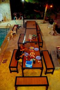 a table with food on it next to a swimming pool at Baanphet Sukphrom Wang Nam Khiao in Ban Khlong Ta Sang