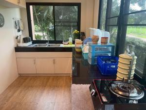 a kitchen with a sink and a counter top at Baanphet Sukphrom Wang Nam Khiao in Ban Khlong Ta Sang +22 photos