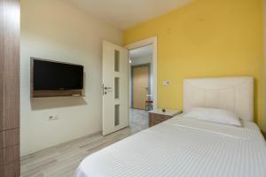 a bedroom with a white bed and a flat screen tv at Premium Rezidans Otel in Antalya