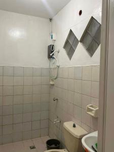 a small bathroom with a toilet and a sink at Cebu Cozy Affordable Transient Room Wifi Netflix Shower Heater in Cebu City