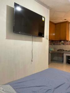 a flat screen tv hanging on a wall at Cebu Cozy Affordable Transient Room Wifi Netflix Shower Heater in Cebu City