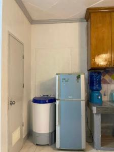 a kitchen with a refrigerator and a trash can at Cebu Cozy Affordable Transient Room Wifi Netflix Shower Heater in Cebu City