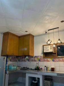 a kitchen with wooden cabinets and a microwave at Cebu Cozy Affordable Transient Room Wifi Netflix Shower Heater in Cebu City