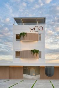 a building with a sign on the side of it at Una Hotel in Mantaak