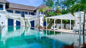 a swimming pool in front of a house at The Trawangan Resort in Gili Trawangan