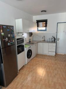 a kitchen with a refrigerator and a washing machine at Sea view apartments in Caesarea