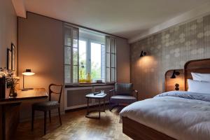 a bedroom with a bed and a desk and a window at Parkhotel Gütersloh in Gütersloh +104 photos