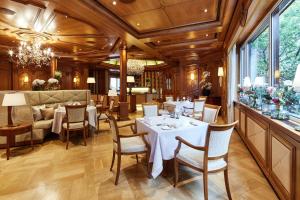 a restaurant with tables and chairs in a room at Parkhotel Gütersloh in Gütersloh