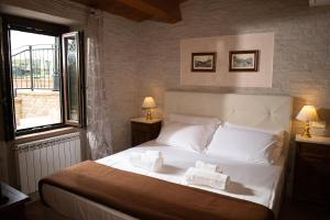 a bedroom with a white bed with towels on it at Colle Indaco Wine Resort & Spa in Ortezzano