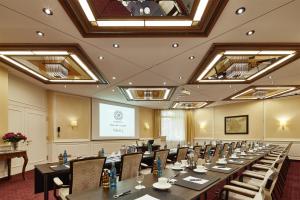 a conference room with a long table and chairs at Parkhotel Gütersloh in Gütersloh
