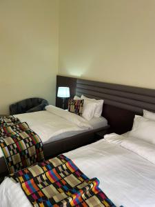 two beds sitting next to each other in a room at Axari Hotel & Suites in Calabar