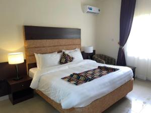 a bedroom with a large bed and two lamps at Axari Hotel & Suites in Calabar